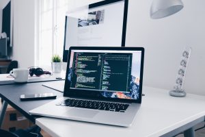 image of a laptop on a desk with a coding browser open