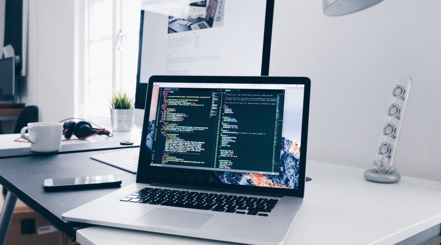 image of a laptop on a desk with a coding browser open